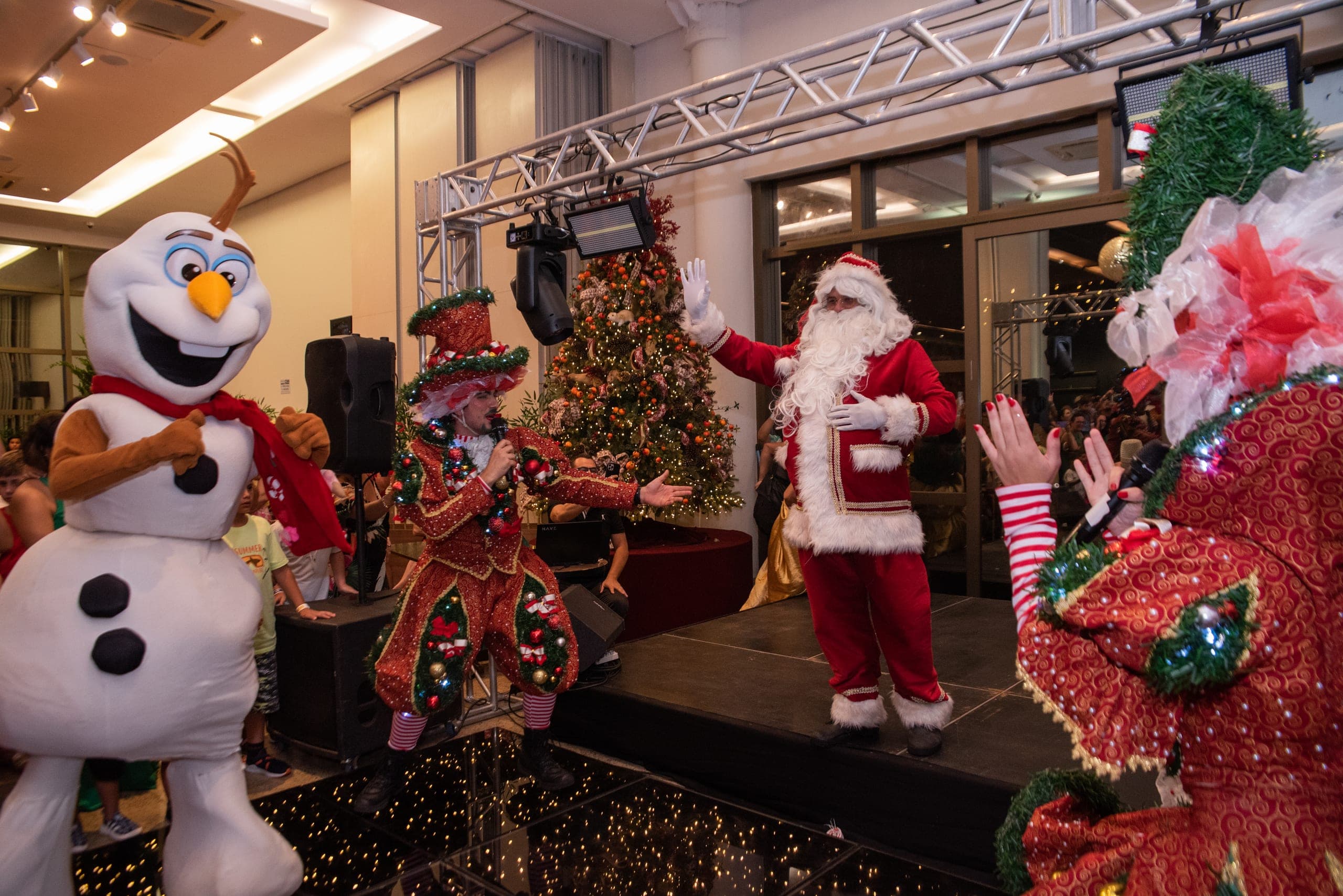 Papai Noel e personagens no show de Natal do Barretos Country Park & Resort, com crianças em volta do palco